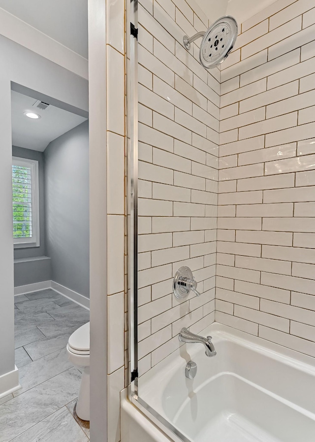 bathroom with toilet, baseboards, and bathtub / shower combination
