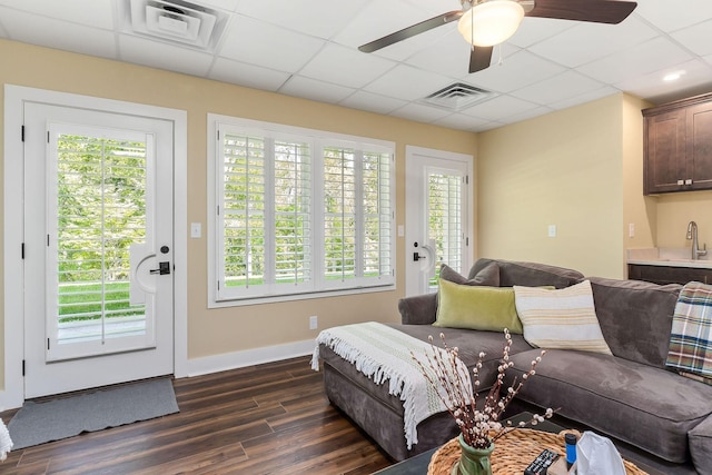 living area with plenty of natural light, visible vents, and dark wood-style floors