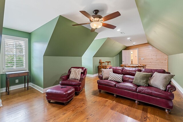 living area with a ceiling fan, baseboards, wood finished floors, and lofted ceiling