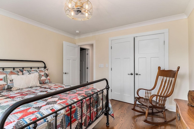 bedroom with crown molding and wood finished floors