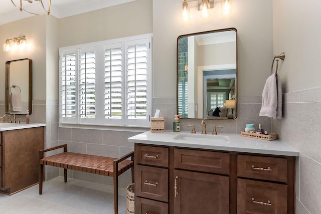 bathroom with wainscoting, vanity, tile walls, and tile patterned flooring