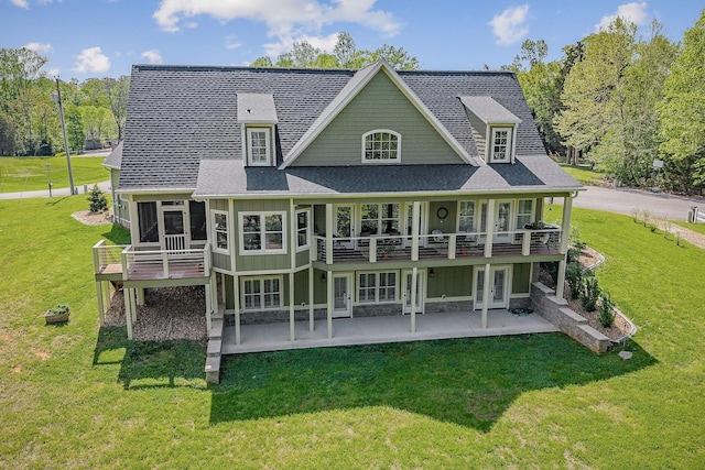 back of property featuring board and batten siding, a patio area, a deck, and a lawn