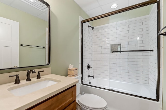 bathroom featuring combined bath / shower with glass door, toilet, and vanity