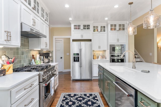 kitchen with dark wood finished floors, under cabinet range hood, high quality appliances, light countertops, and white cabinets