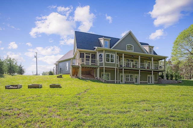 rear view of property featuring a yard, ceiling fan, a sunroom, and a deck