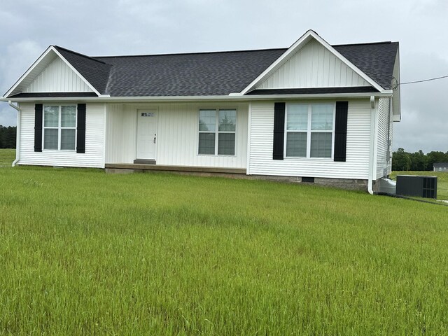 ranch-style home featuring central air condition unit, a front yard, and board and batten siding