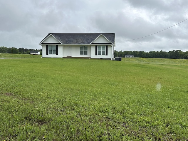 ranch-style home with a front yard and roof with shingles