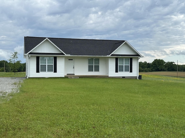 ranch-style home featuring board and batten siding, roof with shingles, and a front yard