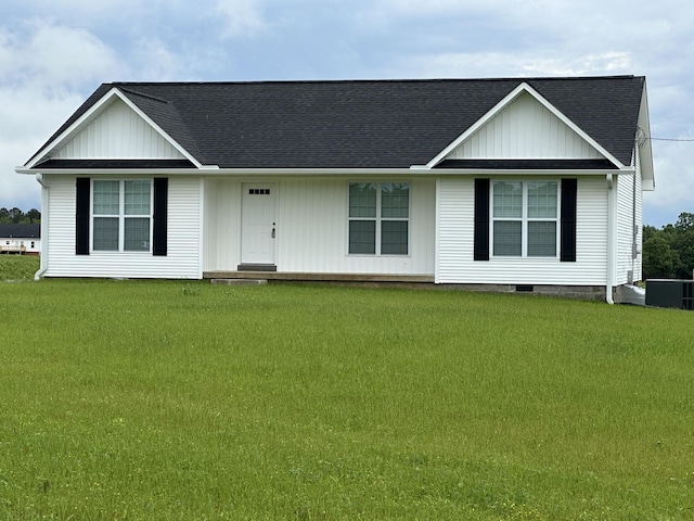 ranch-style home featuring a front lawn, board and batten siding, and roof with shingles