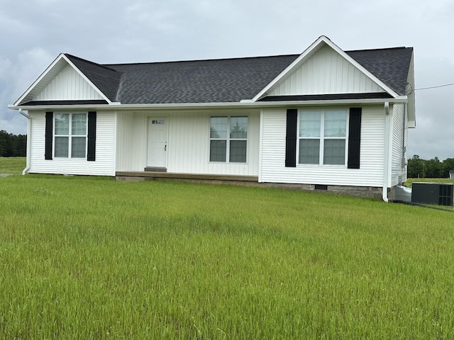 view of front of property featuring board and batten siding, roof with shingles, and a front yard
