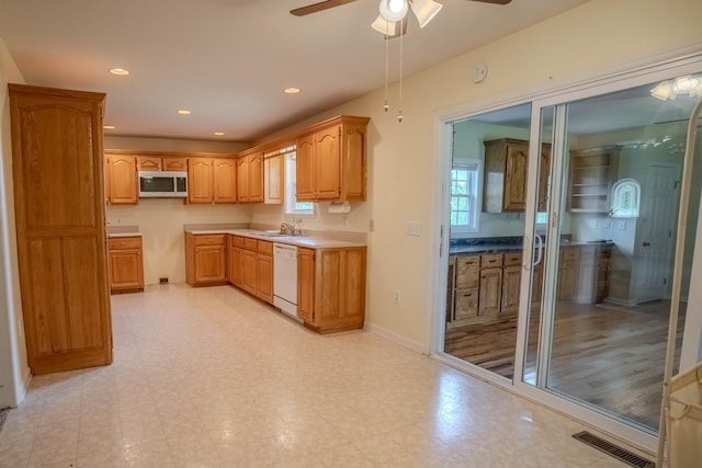 1876 Fall River Rd, Lawrenceburg, TN 38464 - kitchen with stainless steel microwave, white dishwasher, ceiling fan, light floors, and a sink