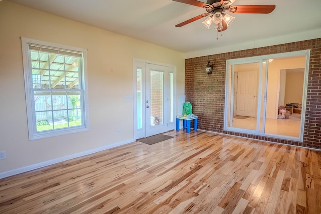 1876 Fall River Rd, Lawrenceburg, TN 38464 - unfurnished room with brick wall, light wood finished floors, healthy amount of natural light, ceiling fan, and baseboards