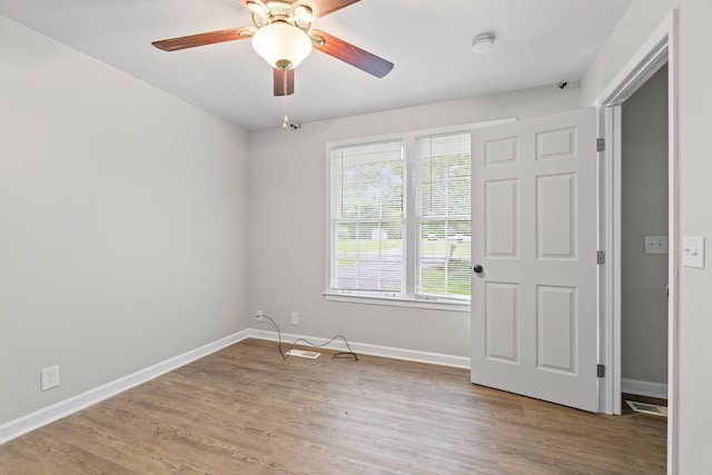 empty room with wood finished floors, baseboards, and ceiling fan