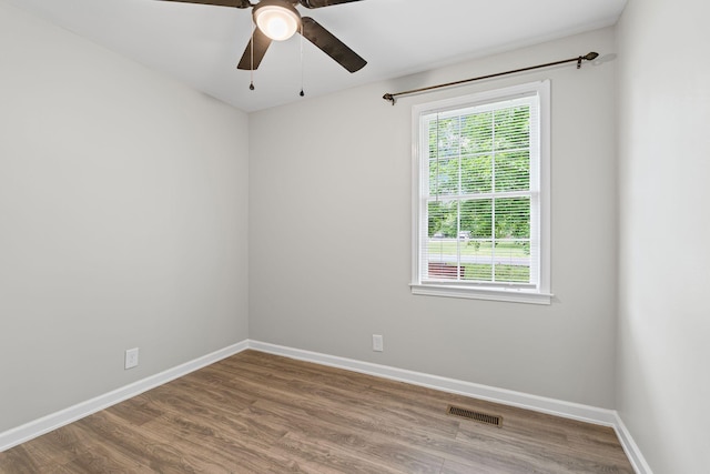 empty room with baseboards, visible vents, and wood finished floors