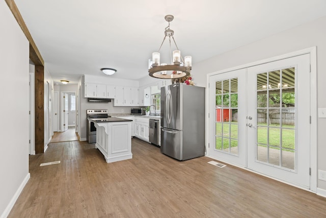 kitchen featuring appliances with stainless steel finishes, french doors, an inviting chandelier, visible vents, and light wood-type flooring