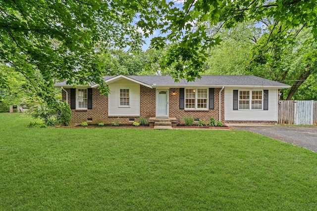 single story home featuring aphalt driveway, fence, brick siding, crawl space, and a front yard