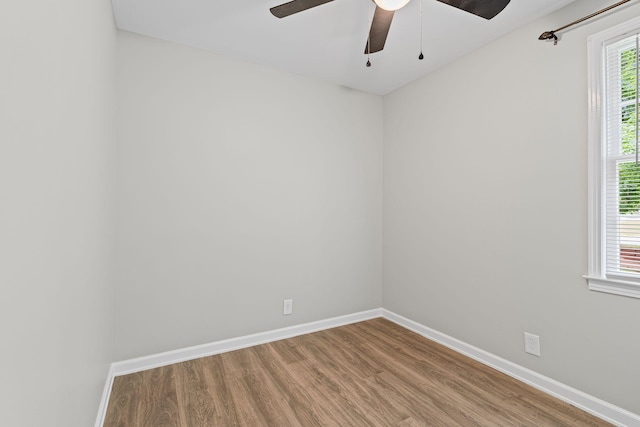 empty room featuring baseboards, a ceiling fan, and wood finished floors