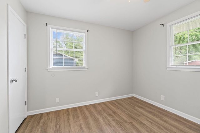 spare room featuring wood finished floors and baseboards