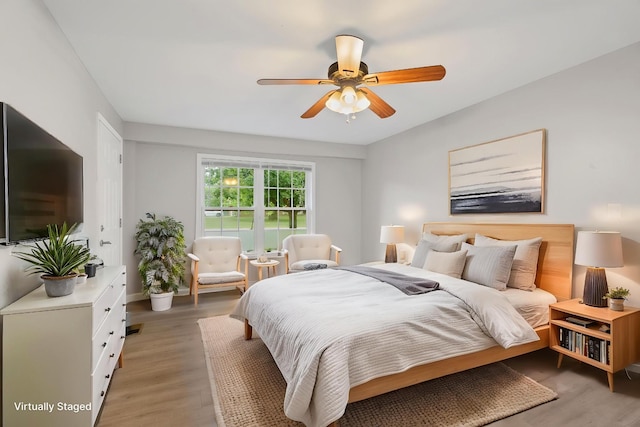 bedroom with baseboards, light wood finished floors, and ceiling fan