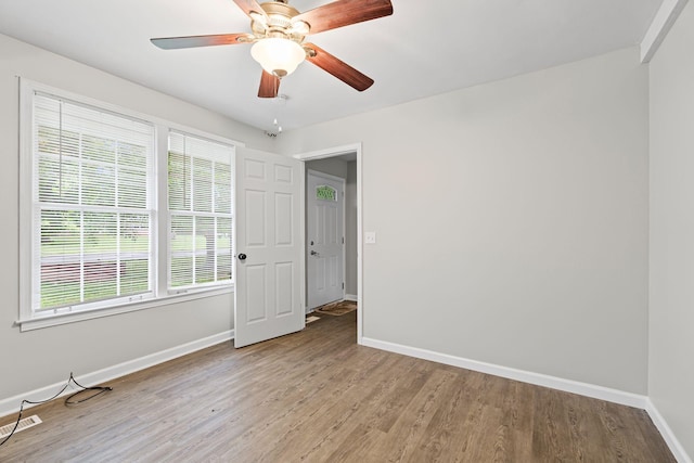 spare room with light wood finished floors, visible vents, baseboards, and a ceiling fan