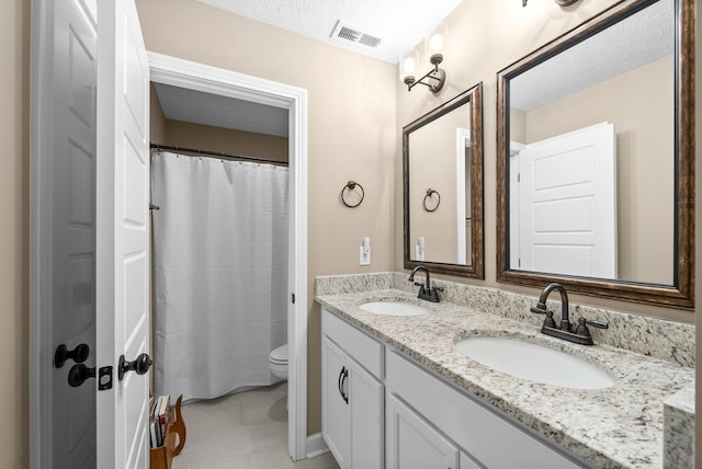 bathroom featuring a sink, double vanity, toilet, and visible vents
