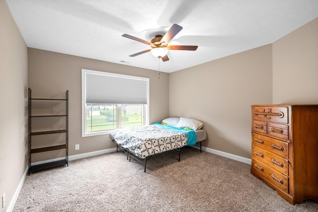 carpeted bedroom featuring ceiling fan, a textured ceiling, baseboards, and visible vents