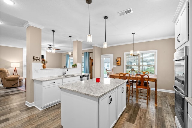 kitchen with a center island, visible vents, a sink, dark wood-type flooring, and appliances with stainless steel finishes