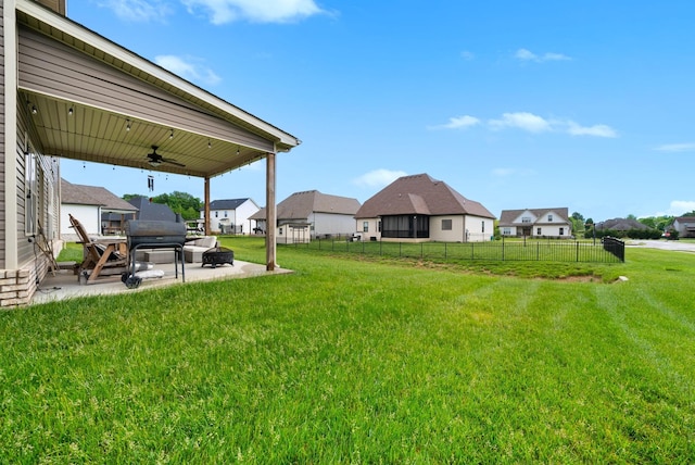 view of yard featuring fence, a patio, a ceiling fan, and a residential view