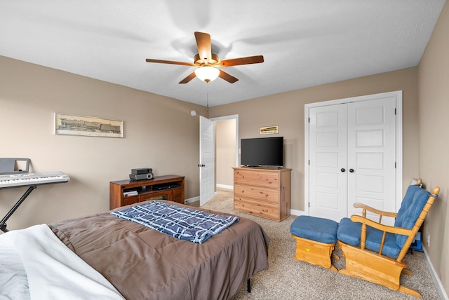 bedroom with carpet flooring, a closet, baseboards, and a ceiling fan