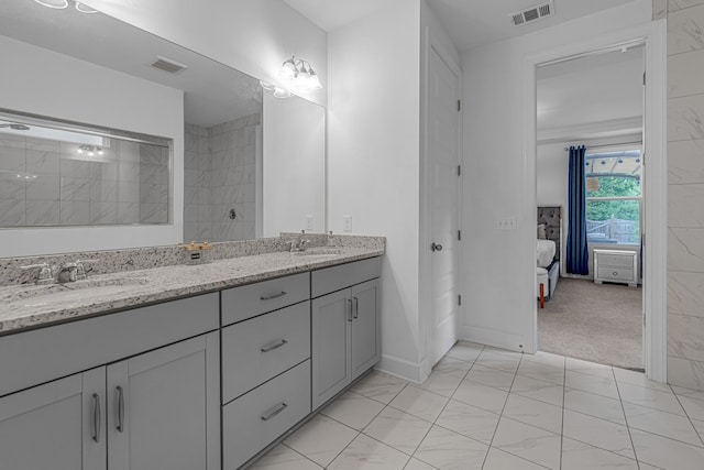 bathroom featuring double vanity, baseboards, and tiled shower