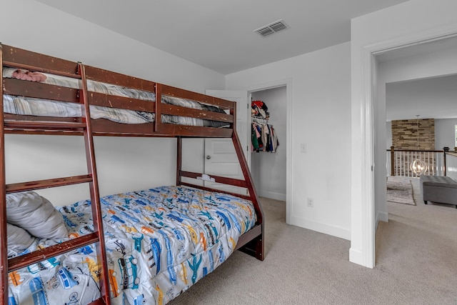 carpeted bedroom featuring a spacious closet, a closet, and baseboards