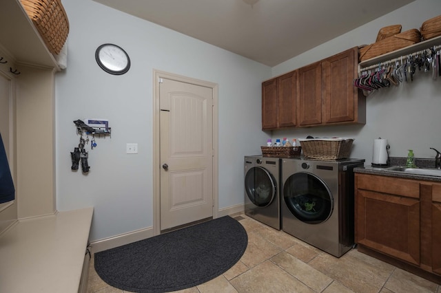 laundry area featuring cabinet space, washing machine and dryer, light tile patterned floors, and baseboards