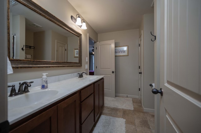 bathroom featuring double vanity, baseboards, and tile patterned flooring