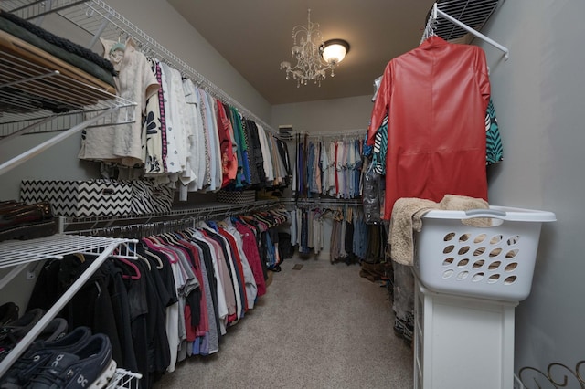walk in closet with carpet flooring and a chandelier