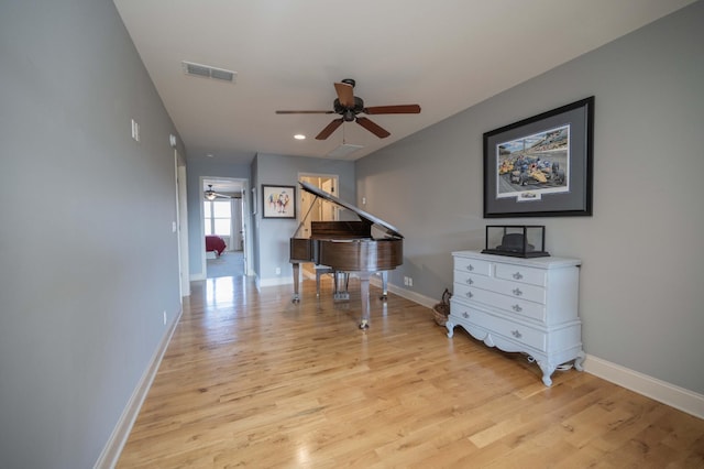 hallway featuring light wood-style flooring, baseboards, and recessed lighting