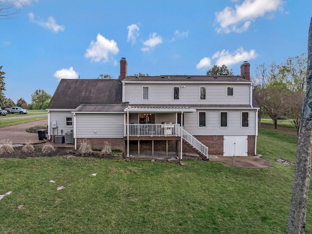 121 Grassland Dr, Gallatin, TN 37066 - rear view of property featuring a wooden deck, a chimney, a lawn, and brick siding