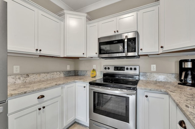 kitchen with appliances with stainless steel finishes, white cabinetry, and light stone counters