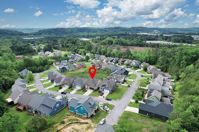 view of property location with nearby suburban area and a heavily wooded area