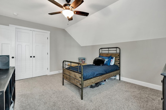 carpeted bedroom with baseboards, vaulted ceiling, ceiling fan, and a closet