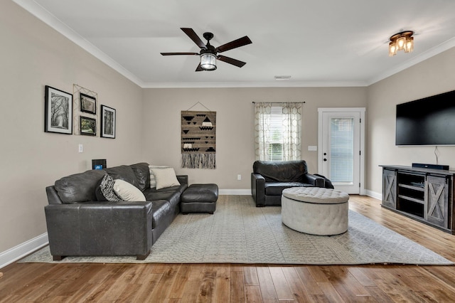 living room featuring crown molding, wood finished floors, a ceiling fan, and baseboards