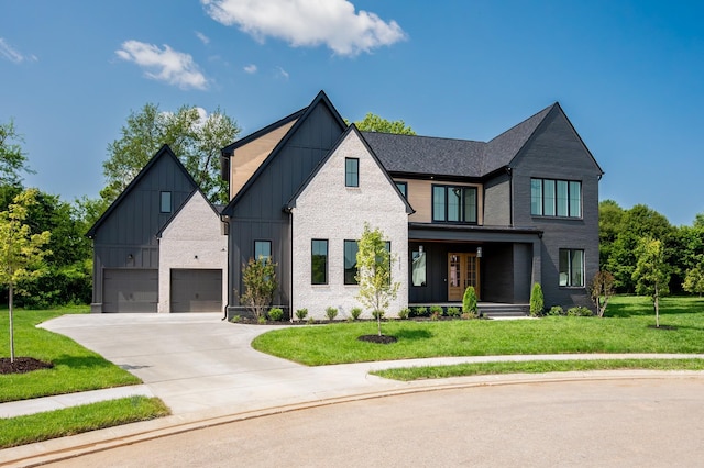 modern farmhouse with concrete driveway, board and batten siding, a front lawn, covered porch, and brick siding