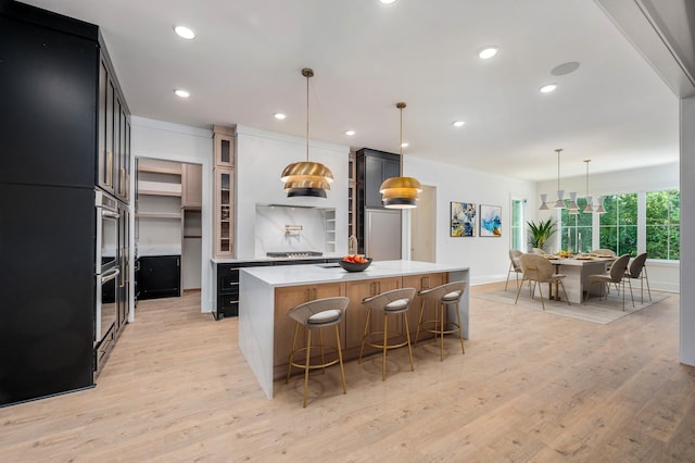 kitchen with light countertops, a spacious island, light wood-type flooring, glass insert cabinets, and recessed lighting