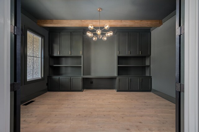 unfurnished dining area with beam ceiling, a chandelier, and light wood-style floors