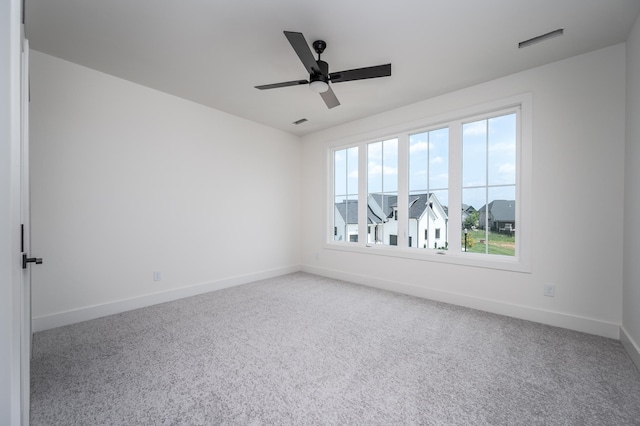 carpeted empty room with baseboards and a ceiling fan