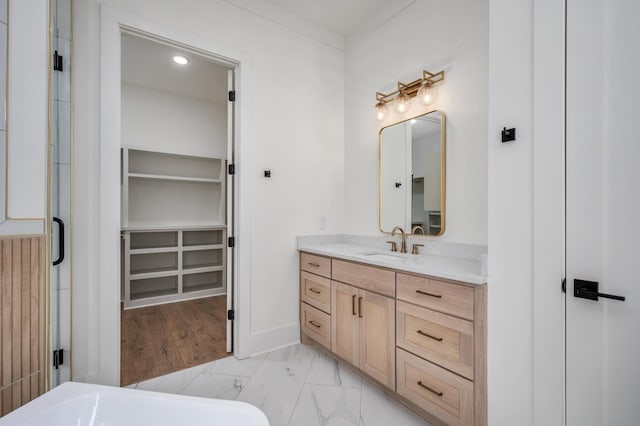 full bathroom with a walk in closet, vanity, and marble look tile flooring