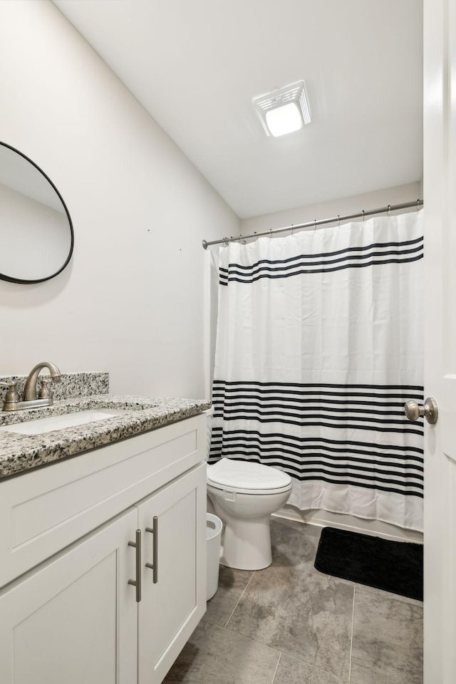 bathroom featuring toilet, vanity, and a shower with curtain