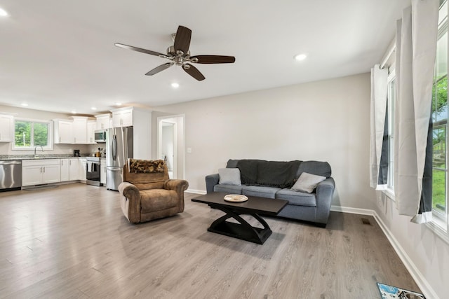 living room featuring light wood-style flooring, recessed lighting, baseboards, and ceiling fan