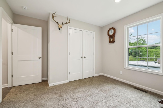 unfurnished bedroom featuring baseboards, multiple windows, carpet, and recessed lighting