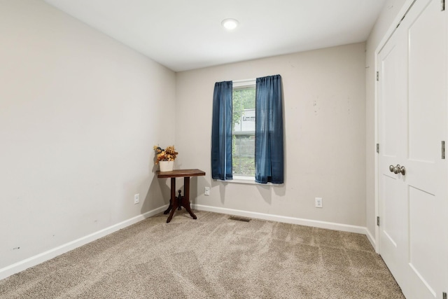 carpeted spare room featuring baseboards