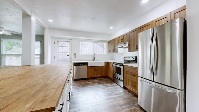 5900 New Hope Ct, Hermitage, TN 37076 - kitchen with appliances with stainless steel finishes, under cabinet range hood, a sink, wood finished floors, and light countertops